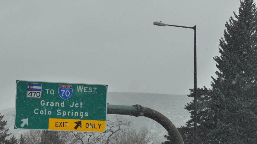 Grand Junction, Colorado Springs Exit to Interstate 70 Highway Road Sign, Snowy Colorado Winter Day, Driver POV Slow Motion