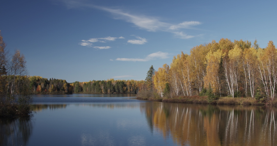Lake in Wisconsin in Fall or Autumn with Calm Water Forest Leaves Trees Yellow