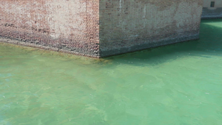 The brick wall rising up out of the ocean in the mote area of Fort Jefferson, part of Dry Tortugas National Park in the Florida Keys, 70 miles off the western coast of Key West.