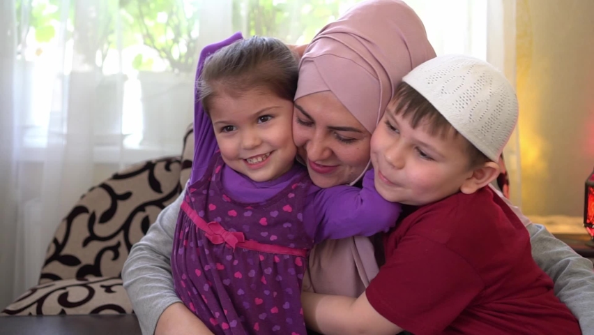 Ramadan mubarak. Muslim family at home together. Happy woman celebrates Eid holiday with a little daughter and son. Children hug their mother Royalty-Free Stock Footage #1070664766