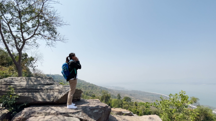 Woman tourists stand shouting at the cliffs and vast views, showing the freedom of travel.