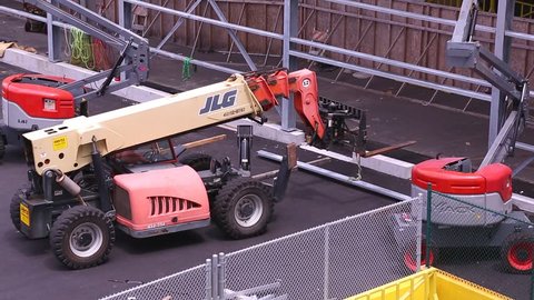 HONOLULU, HAWAII - JULY 2015: Forklift lifts metal beam up to workers on Hawaiian construction site 