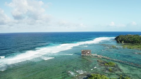 Cloud 9, well-known surfing spot on Siargao Island, Philippines. Observation tower for jury and tourists during surfing competition. Turquoise shallow water. Aerial view, wide angle, 4k