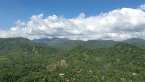 Flying over mountain range. Clear blue sky. Lush beautiful jungle. 4K UHD drone footage.