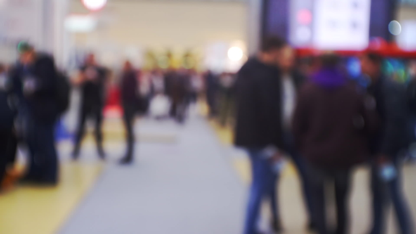 Many people inside a large bright hall inside the business center.Blurred background on a business theme.