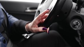 Video, woman hands drive a car, fingers lie on the steering wheel, beautiful fingers with a purple manicure