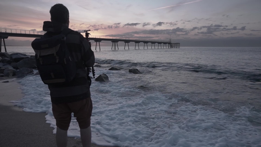Professional landscape photographer taking pictures at the beach at sunrise.