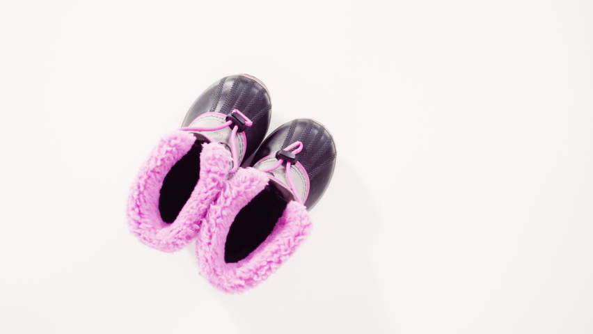 Flat lay. Little girl pink and gray warm and waterproof winter boots on a white background.