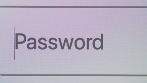Entering weak and strong passwords in a password box on a computer screen, close up