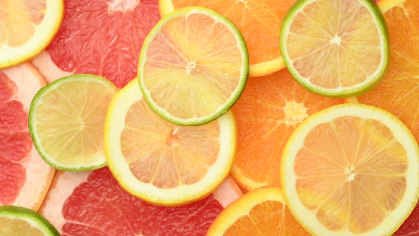 Citrus fruits slices such as oranges, grapefruits, lemons and limes, rotating, top view Royalty-Free Stock Footage #1070695099