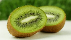 Kiwi juicy tropical fruit rotating 360 slow motion on a green background. 4K Video close-up of a summer tropical fruit.