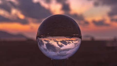 The view in a crystal ball looks like no other. 4K Videos for beautiful and unusual travel ideas. time lapse clouds moving in beautiful sky in sunrise above the sea. 