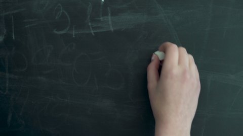 Writing Pi. Writing the number pi on the chalkboard. A female hand writes with white chalk.