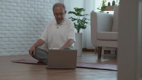 Older people are looking at laptop screens to learn yoga poses online. With expert teachers to give advice on learning all the time. Sports activities for retired seniors concept.
