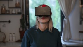 Woman using VR glasses at home in kitchen