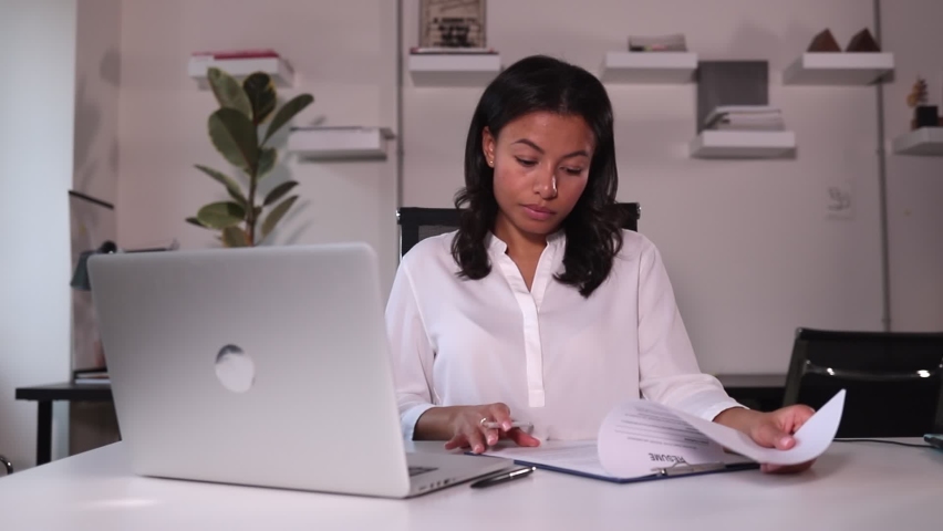 HR manager scrolls through resume through video meeting on computer with Spbi candidate