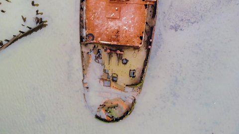 Drone flying vertically over the entire length of abandoned ship at Staten island boat graveyard. Aerial.