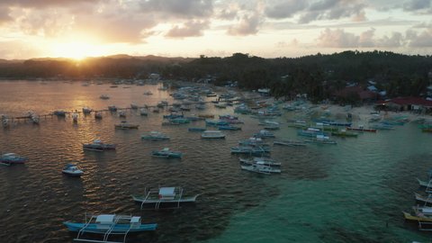 Outrigger Boats moored in the harbour with sunset in General Luna, Siargao Island, Philippines.