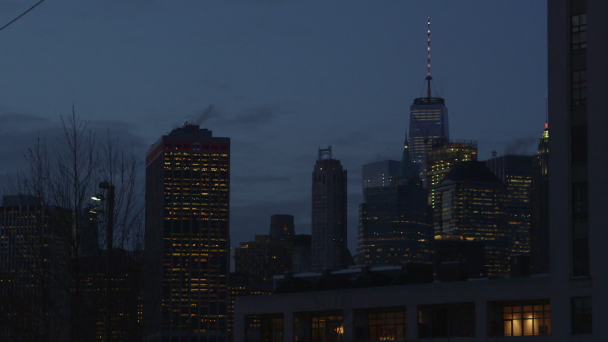 Establishing shot of New York City at dusk showing the skyline and the East River with the lights in the buildings on a cold day in 2017.  Cinematic setting shot filmed with a tripod for title screens Royalty-Free Stock Footage #1070722102