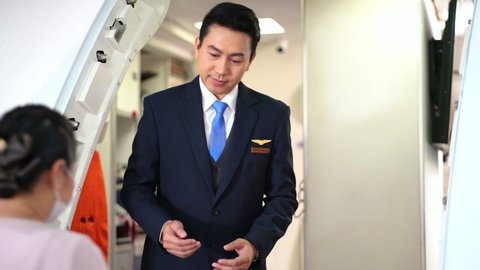 Asian flight attendants greeting passenger walking on board at international airport in summer vacation holiday a transportation concept