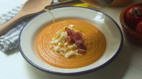 Serving Traditional tapa Salmorejo from south Spain. Cold tomato soup with ham, egg and olive oil.