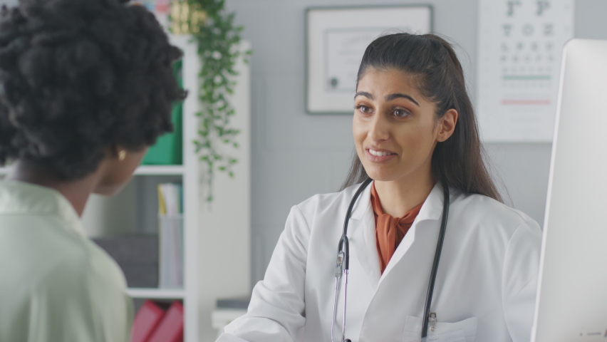 Female doctor or consultant wearing white coat having meeting with female patient in office - shot in slow motion | Shutterstock HD Video #1070734987