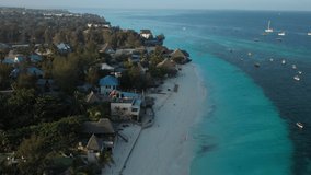 Aerial video: flies over the coast of the Indian Ocean during dawn, beautiful azure water and beaches in the frame, tropical paradise