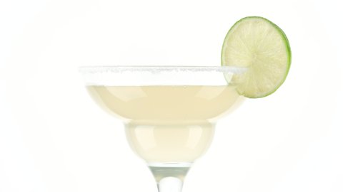 cocktail Margarita with lime on white background rotate. Glass with a cocktail. Party, Success, holiday celebrating. 4K UHD video