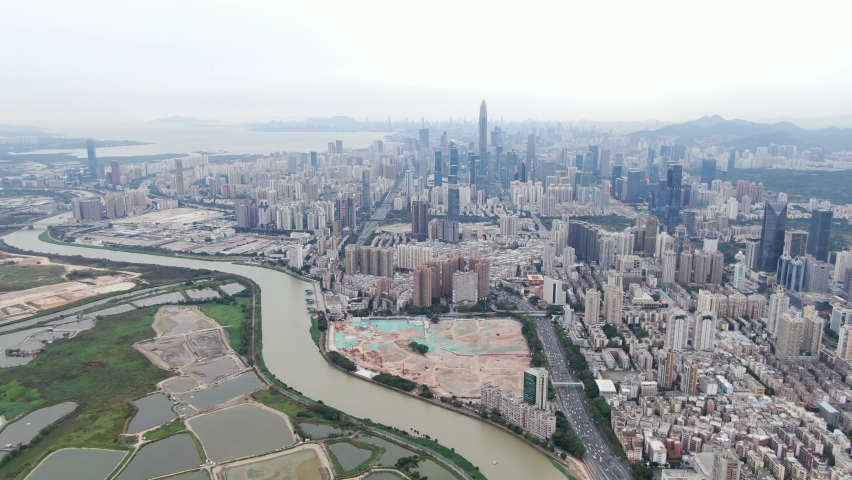 Aerial view over Shenzhen cityscape with massive urban development and skyscrapers.