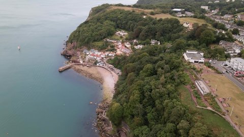Descending aerial view of beautiful ocean landscape with rocky coastline, cliffs,trees and buildings. Babbacombe Beach,Torquay England.