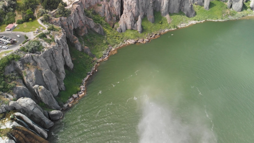 Aerial upward tilt of the cliffs along the Snake River and mist from Shoshone Falls in the foreground near Twin Falls, Idaho.