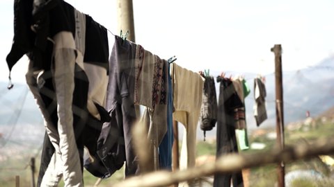 Clean washed clothes hanged on wire, blurred nature background in village