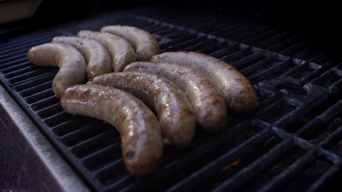 Glistening, plump sausages on the grill on a summer day
