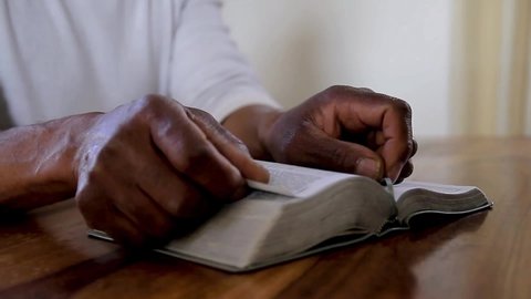man praying with hand on bible at church on Sunday stock footage