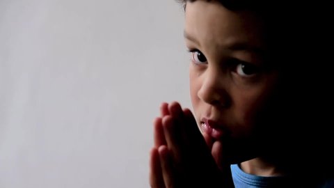boy praying to God with hands together on white background stock footage