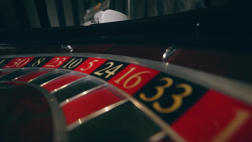 Close up of roulette wheel at the casino in motion. The wheel ball is spinning. Concept of casino and gambling. Royalty-Free Stock Footage #1070763697