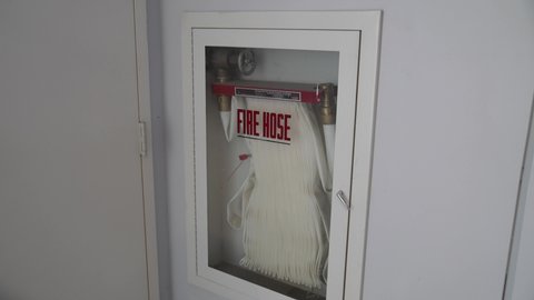 This tilt video shows an emergency fire hose storage unit on a wall.