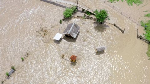 Aerial view of a Flood and flooded houses. Natural disaster and destruction. Fast flowing raging river after strong rain.