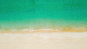 Top-view in drone shot. Video of beach sea. Beautiful sea waves. Beach sand and amazing sea. Summer sunset seascape. Phuket Thailand Beach. Water texture. Top view of the fantastic natural sunsets
