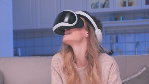 Female Uses Virtual Reality Glasses Looking Learning. Facility Helmet for Simulation Application VR. Close-up Smiling Girl Active Watching Eyes Video in Optical VR Headset. Show Moving Tech Industry 4