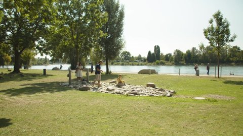 Parents spending Time with their Children in a Park, People walking near the Water