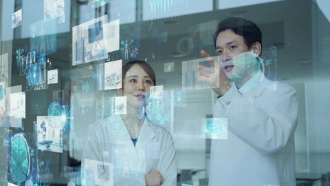 Asian doctors watching hologram screens. Medical technology. Medtech.