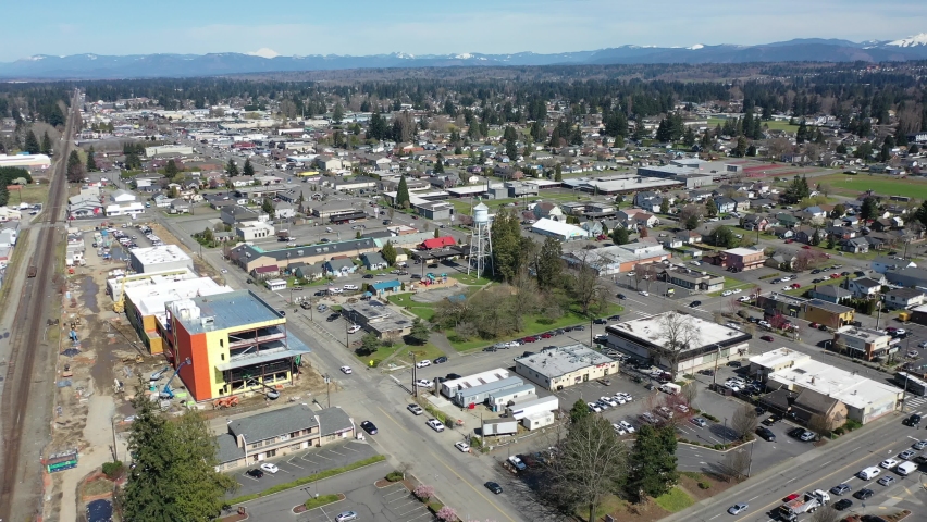 Cinematic orbiting aerial drone clip of downtown Marysville, by the I-5 freeway, a distant suburb, bedroom community North of Seattle on the shores of Puget Sound in Washington