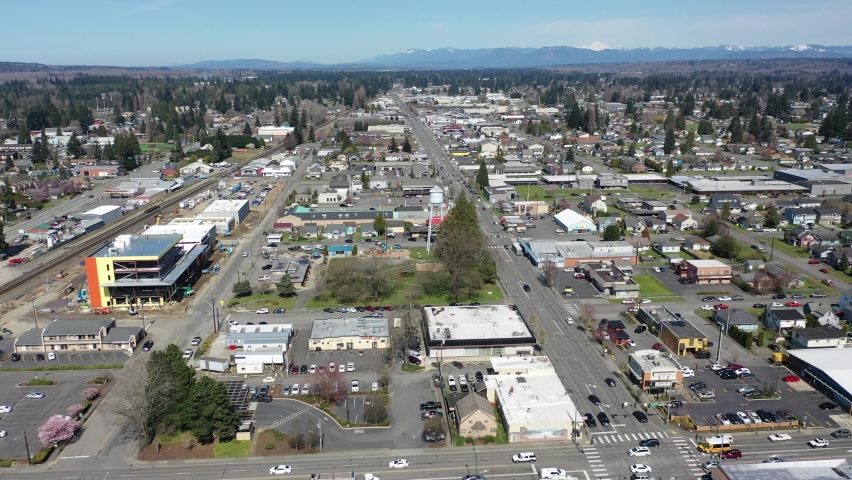Orbiting cinematic aerial drone clip of downtown Marysville, by the I-5 freeway, a distant suburb, bedroom community North of Seattle on the shores of Puget Sound in Washington