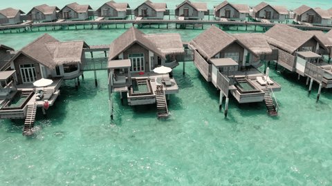 Drone aerial view of water bungalows in The Maldives. Luxury resort filmed from the air with a drone 