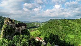 Orava castle - Oravsky Hrad in Oravsky Podzamok in Slovakia. Medieval stronghold on extremely high and steep cliff by the Orava river. Aerial 4K panning video in sunrise light in summer