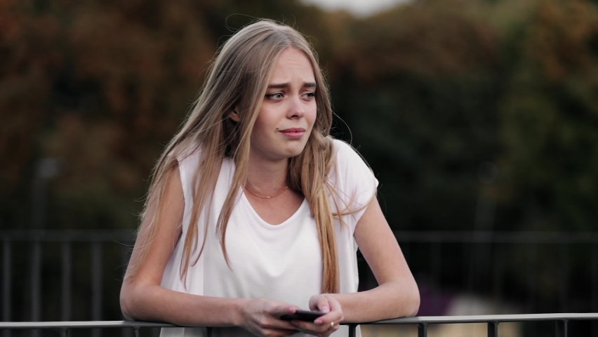 Sad worried young woman attractive face having psychological problem feeling anxiety depression. Woman is crying. Close-up of face of an upset girl
