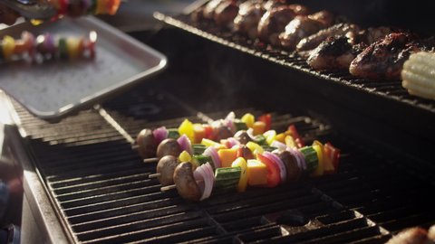 Grillmaster places his famous shish kabobs on the smoking grill