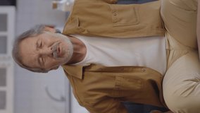 The old man who tries to stretch his back from low waist pain, tries to rub his back, relax a little. Back and waist pain concept.Video for the vertical story.