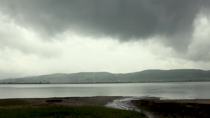 An eerie scenery of stormy clouds over the lake in HD